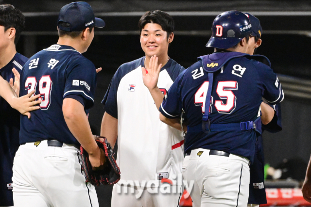 두산 시라카와가 12-1로 승리한 뒤 동료들과 하이파이브를 하고 있다.