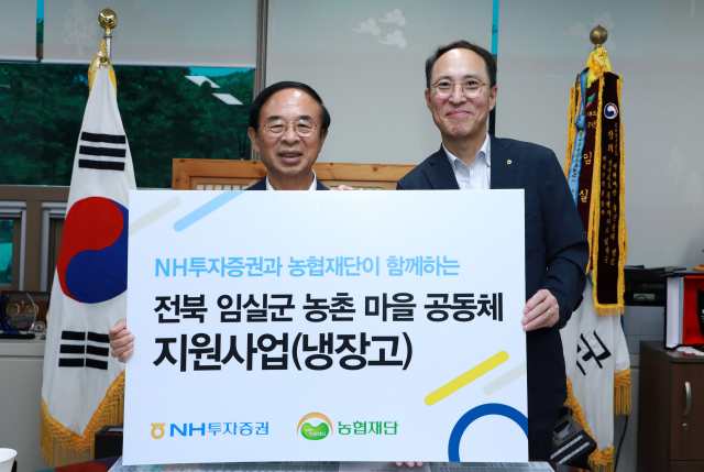 NH투자증권이 전북 임실군에 냉장고 65대를 전달했다고 20일 밝혔다. 김용기(오른쪽) NH투자증권 부사장, 심민 임실군수가 냉장고 전달식에서 기념촬영하고 있다./NH투자증권