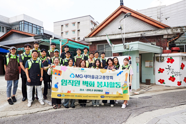 새마을금고중앙회 직원들이 지난 9일 서울 성북구 한천마을에서 벽화그리기 봉사활동을 마치고 기념촬영을 하고 있다./새마을금고중앙회