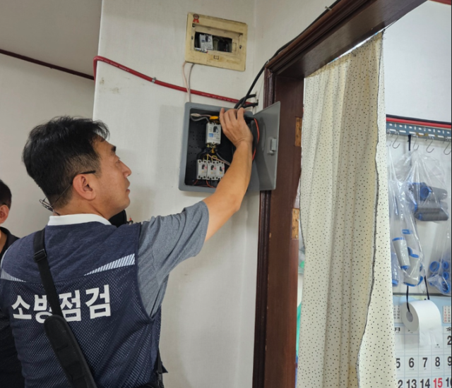 화재보험협회 관계자가 창신 제2동 주택 소방시설 개보수를 하고 있다./화재보험협회